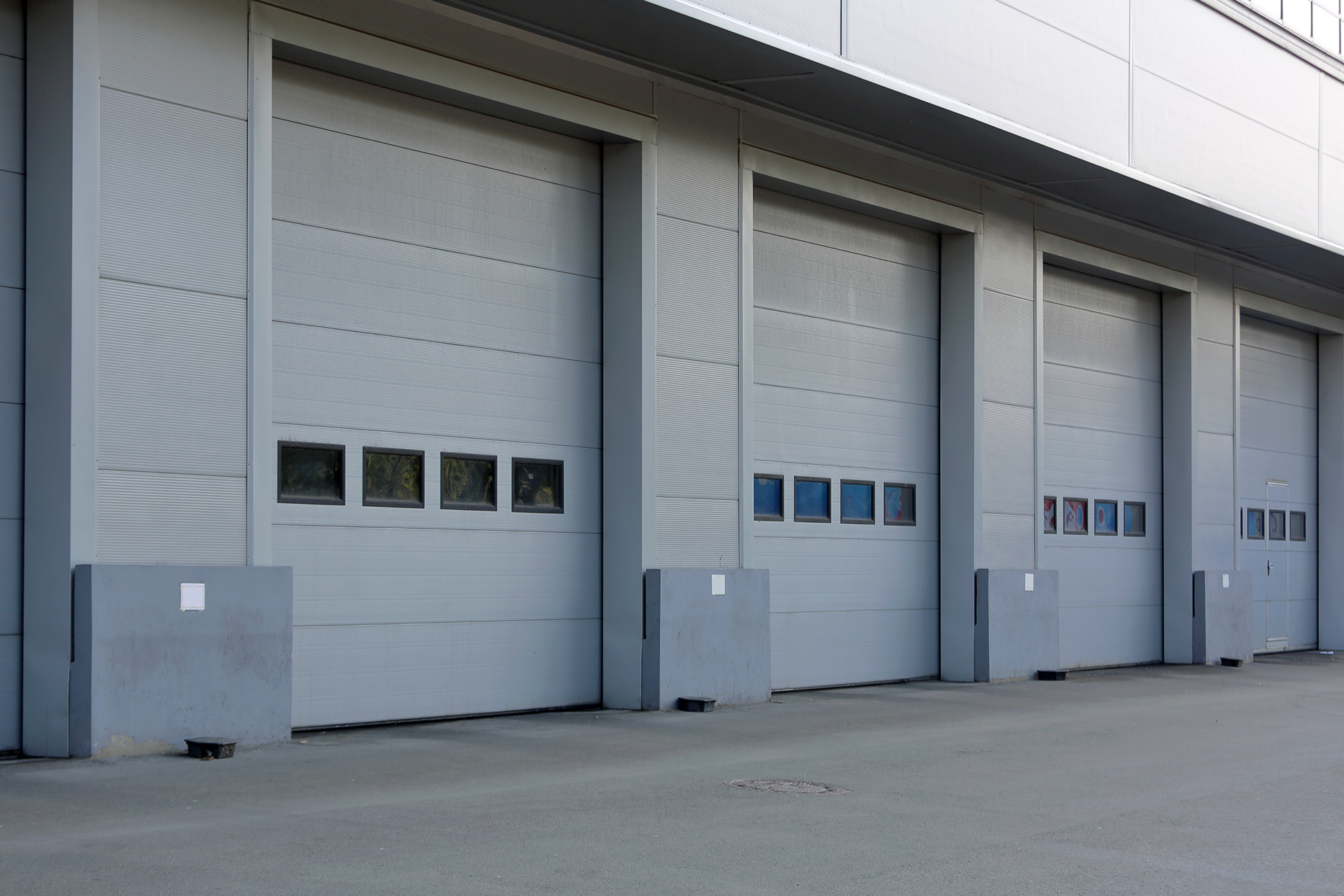 Exterior view of multiple overhead steel garage doors installed in Boyle Heights, CA commercial facility