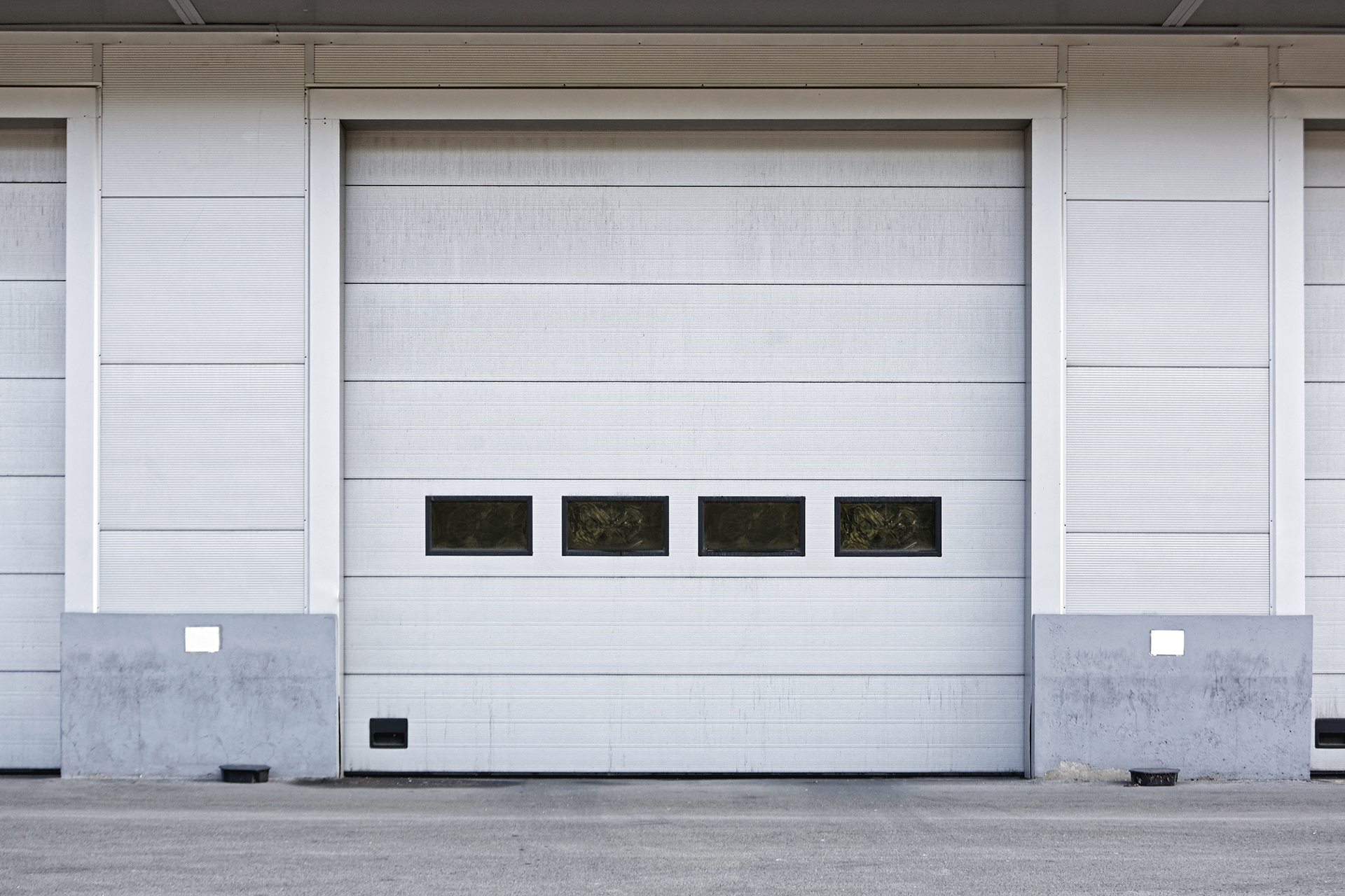 Interior view of commercial loading docks with overhead steel garage doors in Boyle Heights, CA