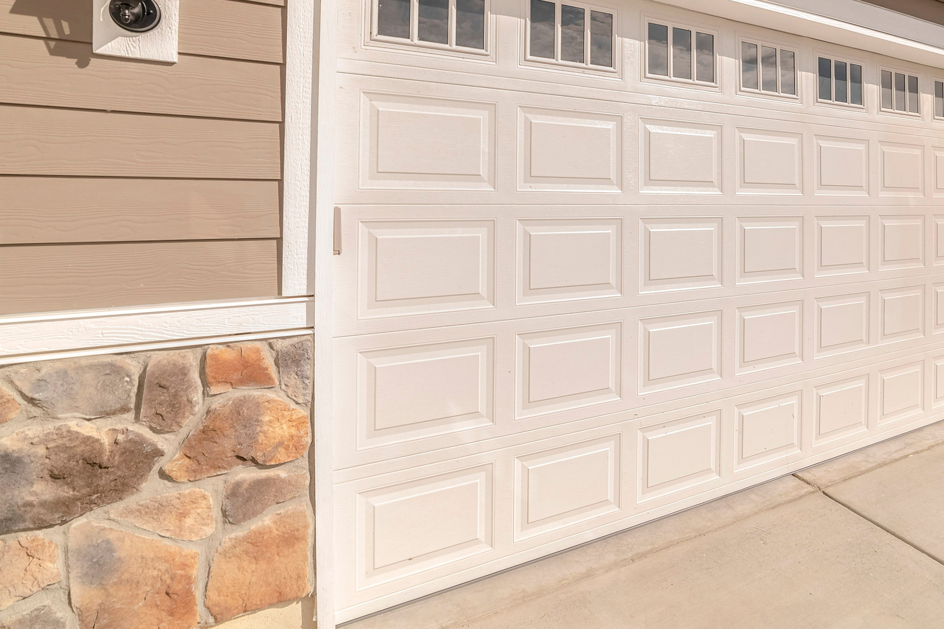 White steel garage door with window panels installed on a residential home in Palmdale, CA